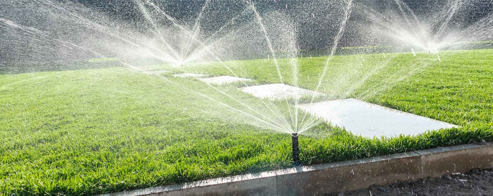 Garden irrigation system lawn. Automatic lawn sprinkler watering green grass - The Role of Landscaping in Energy Efficiency